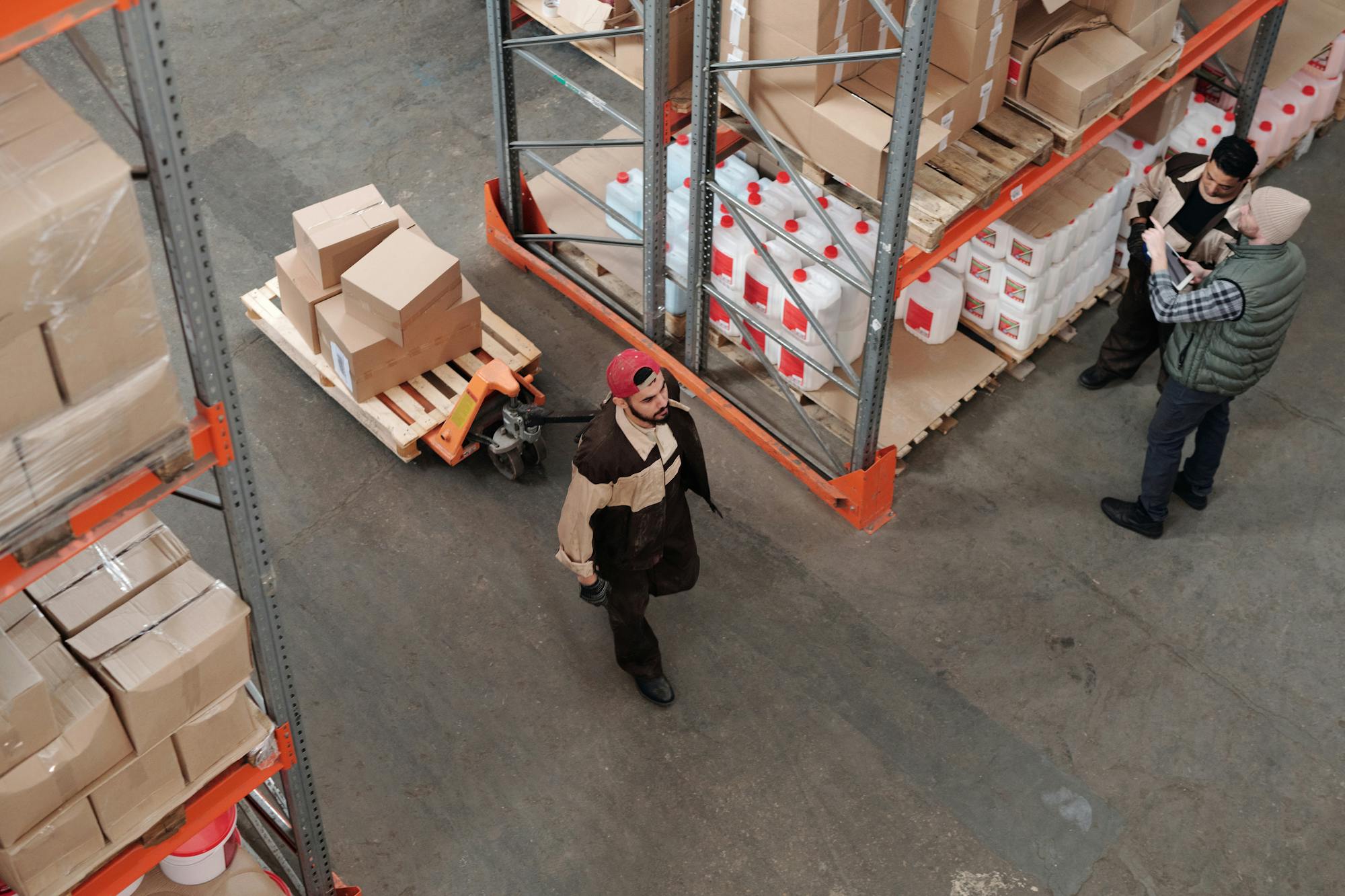 Warehouse manager and assistant reviewing inventory data on tablet